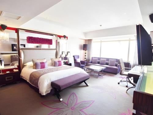 a bedroom with a large bed and a living room at Grand Lisboa Macau in Macau