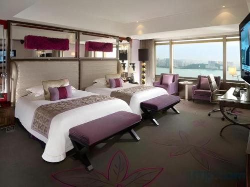 a hotel room with two beds and a television at Grand Lisboa Macau in Macau