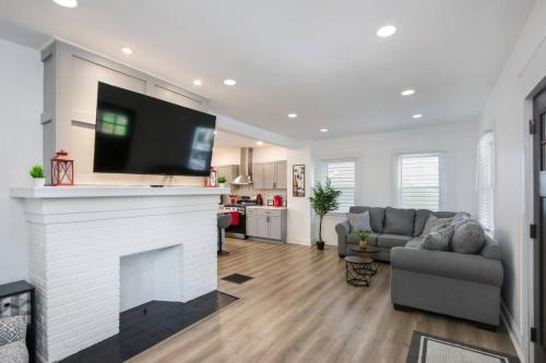 a living room with a fireplace with a tv above it at 5th Street Retreat Private Home OSU, Short North in Columbus
