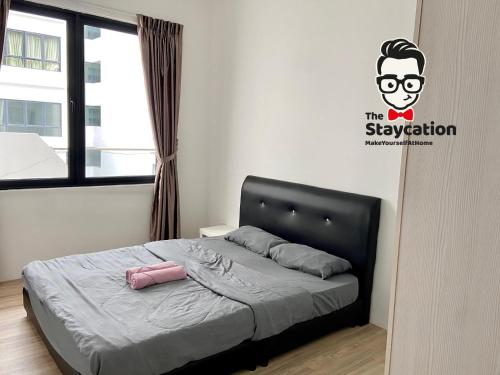 a bedroom with a bed with a pink bag on it at Staycation Homestay 14 P Residence kuching condo in Kuching