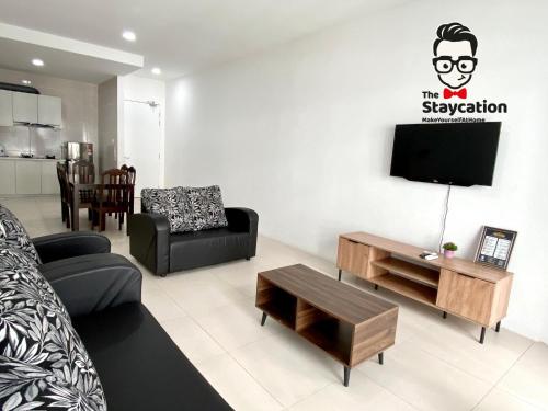 a living room with a couch and a tv at Staycation Homestay 14 P Residence kuching condo in Kuching