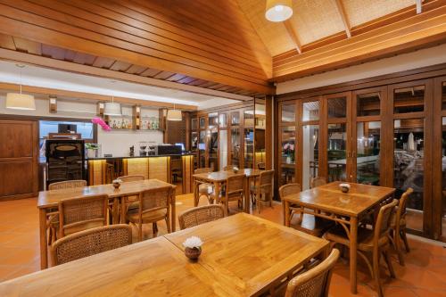 a dining room with wooden tables and chairs at Rimping Village in Chiang Mai