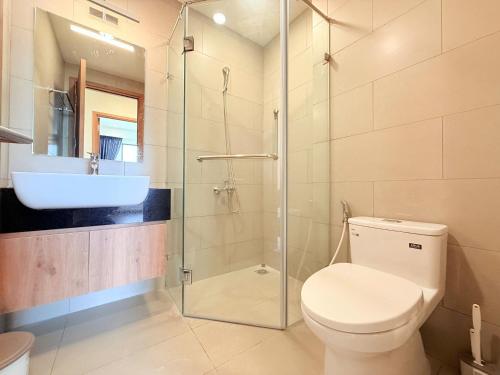 a bathroom with a toilet and a sink and a shower at Homie's The Glory Apartment in Thu Dau Mot