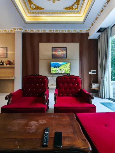 a living room with two red chairs and a table at Long Homestay Xuyên Á - Hotels in Ðức Hòa