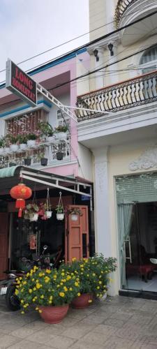 a building with flowers in front of a store at Long Homestay Xuyên Á - Hotels in Ðức Hòa