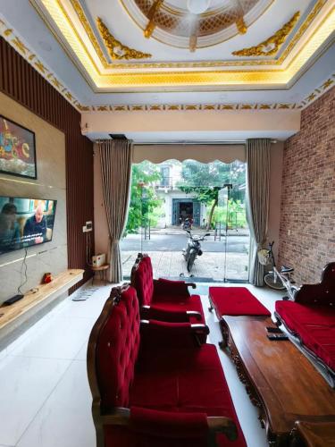 a living room with a red couch and a large window at Long Homestay Xuyên Á - Hotels in Ðức Hòa