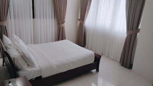 a bedroom with a bed and a window with curtains at Mactan Resort by 1521 in Mactan