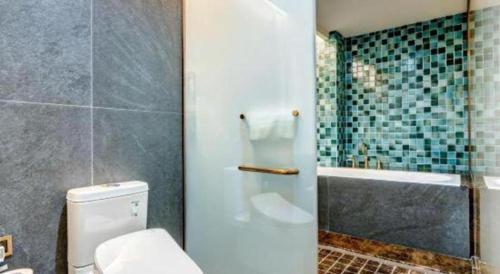a bathroom with a toilet and a bath tub at James Joyce Coffetel·Anyang Text Museum in Anyang