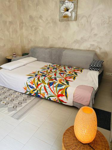 a bedroom with a bed with a colorful blanket at Maison propre et calme à 5 min du Futuroscope in Chasseneuil-du-Poitou