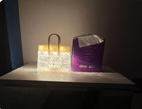 a candle and a bag sitting on a shelf at Winners of 2025 traveller Award, Elegant two bedroom city central apartment with Netflix & WiFi in Leeds