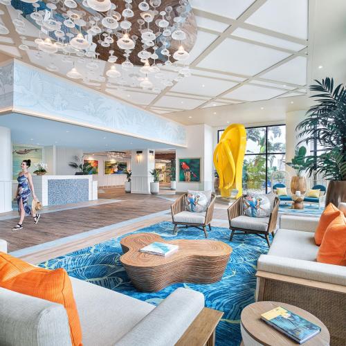 a woman walking through a lobby with a living room at Margaritaville Beach Resort South Padre Island in South Padre Island