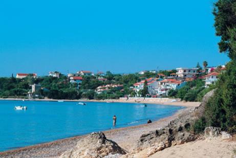 Blick auf einen Strand mit Gebäuden im Hintergrund in der Unterkunft Theoxenia Hotel Apartments in Chrani