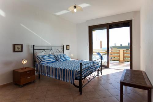 a bedroom with a bed and a table and a window at Elena House in Alghero
