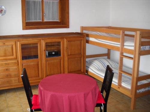 a dining room with a table and bunk beds at Chambre d'hôtes Littoral 65 in Chez-le-Bart