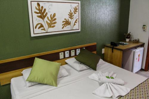 a hotel room with two beds with green walls at Abrolhos Praia Hotel in Fortaleza