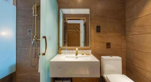 a bathroom with a sink and a toilet and a mirror at James Joyce Coffetel Kunming Railway Station Huancheng Nan Road Metro Station in Kunming