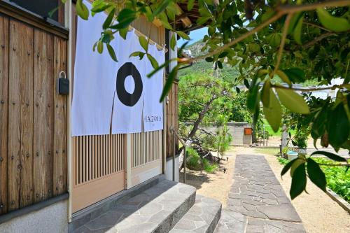 a door with a number eight sign on the side of a house at 間 はざま in Shodoshima