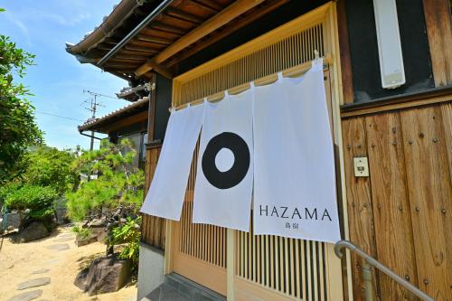 a sign on the side of a building with a haniana sign at 間 はざま in Shodoshima