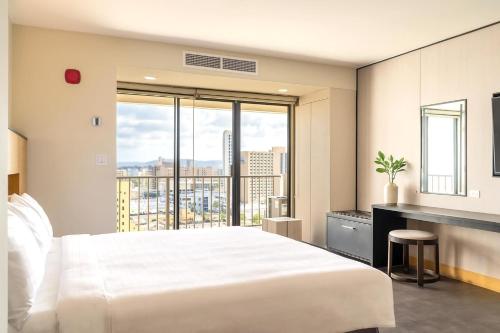 a bedroom with a large white bed and a large window at The Bayview Hotel Guam in Tumon