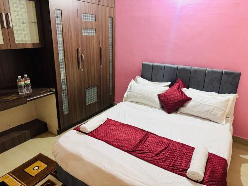 a bedroom with a large bed with red and white pillows at LUXE Premium homestay in Mysore