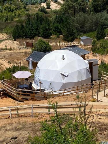 a large white tent with umbrellas in a field at Domos el Quillay in Concepción