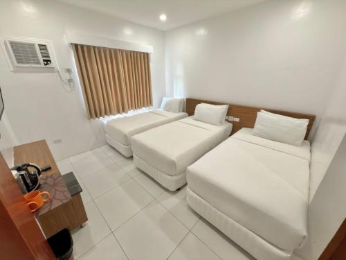 a living room with two beds and a couch at Cris Inn Tagum in Tagum