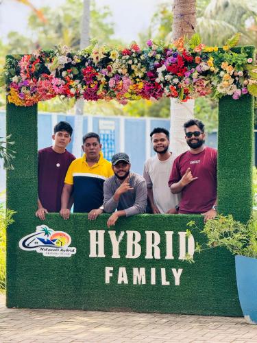 a group of men standing in front of ayrrl family sign at Nilaveli Hybrid Holiday Hotel in Nilaveli