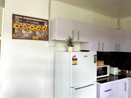 a kitchen with white cabinets and a white refrigerator at Large 3bdr Holiday Home Great Location Labasa Jumanzuls Abode in Labasa