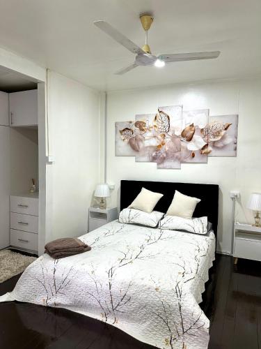 a white bedroom with a large bed and a ceiling fan at Large 3bdr Holiday Home Great Location Labasa Jumanzuls Abode in Labasa