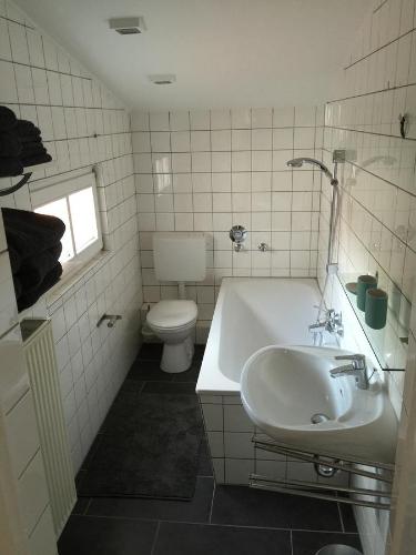 a bathroom with a tub and a toilet and a sink at SEELIG`S in Weinsheim