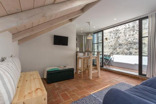 a living room with a couch and a table and a window at Casas da Formosa - Casa do Postigo in Tavira