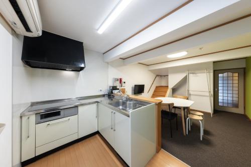 an apartment kitchen with a sink and a table at Asobi TABI-NE in Kanazawa