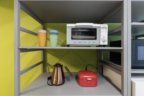 a kitchen with a microwave and a toaster oven at Asobi TABI-NE in Kanazawa