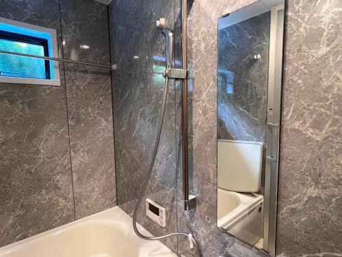 a bathroom with a shower and a bath tub at LIFEMENT GLANZ Okimi in Etajima
