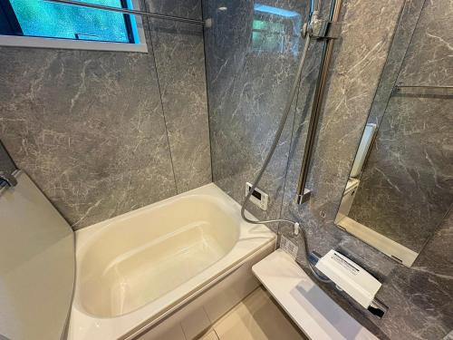 a bathroom with a shower and a bath tub at LIFEMENT GLANZ Okimi in Etajima