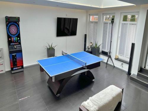 a blue ping pong table in a room with a tv at Apartment with bar, recreation room in Kastellaun in Kastellaun