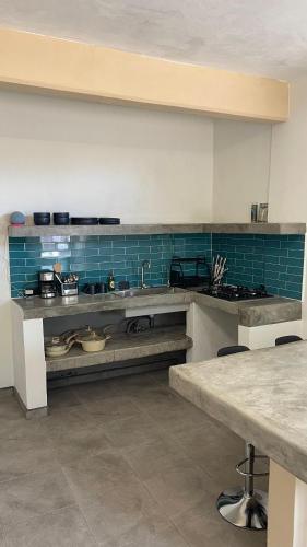 a large kitchen with blue tiles on the wall at Casa Marlin in Mulegé