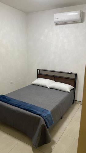 a bed with two pillows and a air conditioner at Casa Marlin in Mulegé