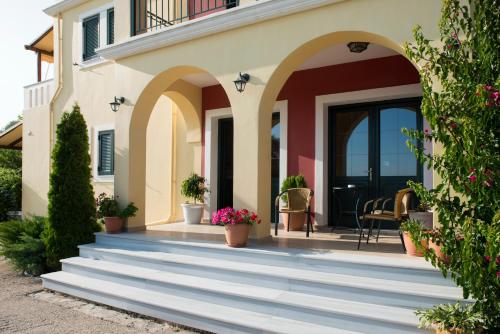 a home with stairs leading to the front door at Irida in Lefkada Town
