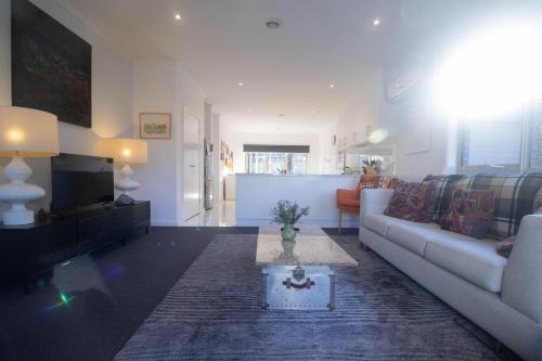 a living room with a couch and a table at Canvas & Comfort in Wendouree