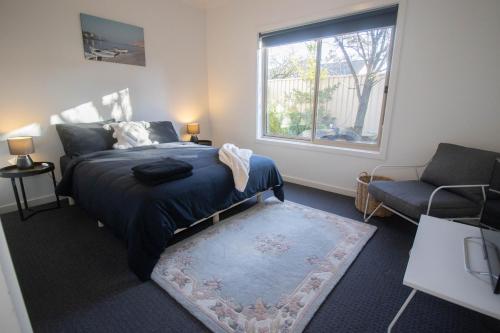 a bedroom with a bed and a couch and a window at Canvas & Comfort in Wendouree