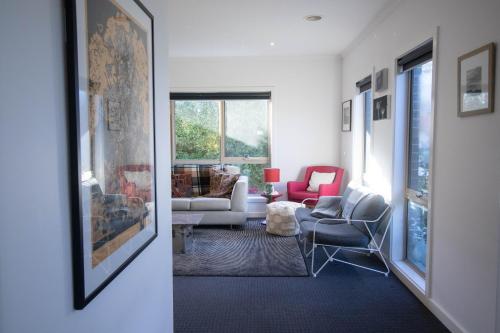 a living room with couches and chairs and a window at Canvas & Comfort in Wendouree