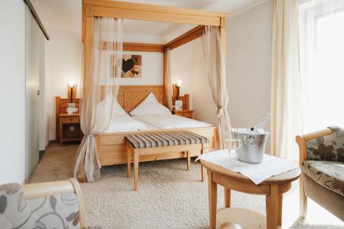 a bedroom with a bed with a canopy at Landgasthof & Hotel zur Rose Berg in Ehingen