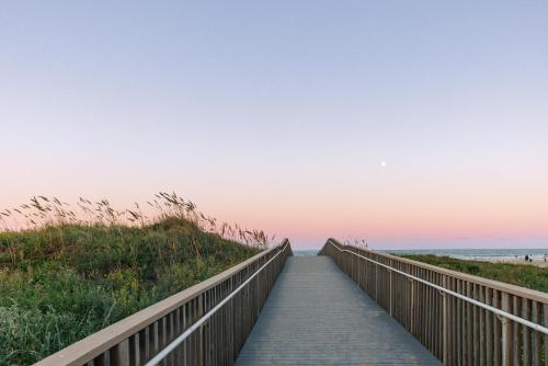a boardwalk to the beach at sunset at Margaritaville Beach Resort South Padre Island in South Padre Island