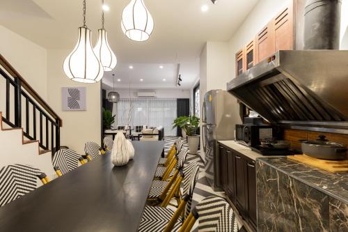 a kitchen with a black counter and chairs at Nimman Nest AndLae Living in Chiang Mai
