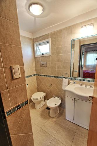 a bathroom with a toilet and a sink at Sonnen Haus in Villa General Belgrano