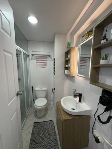a small bathroom with a toilet and a sink at Amani 311 Suites - Double bed with Single Pull Out Bed in Pusok