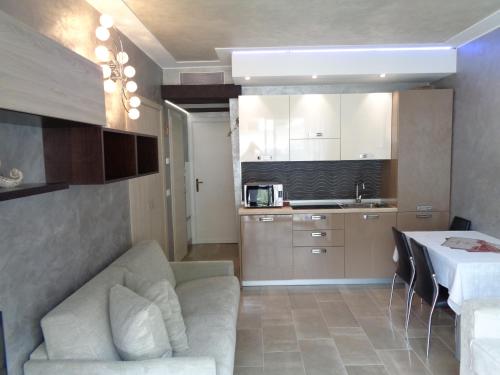 ein Wohnzimmer und eine Küche mit einem Sofa und einem Tisch in der Unterkunft Studio Le Marly in Menton