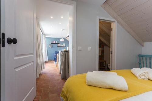 a bedroom with a yellow bed with a yellow blanket at Casas da Formosa - Casa do Postigo in Tavira