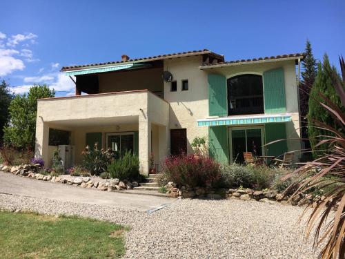a house with a green and white at Les Mimosas Apartments in Villelongue-dels-Monts
